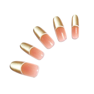 Gold French tip oval press-on nails with nude base on white background