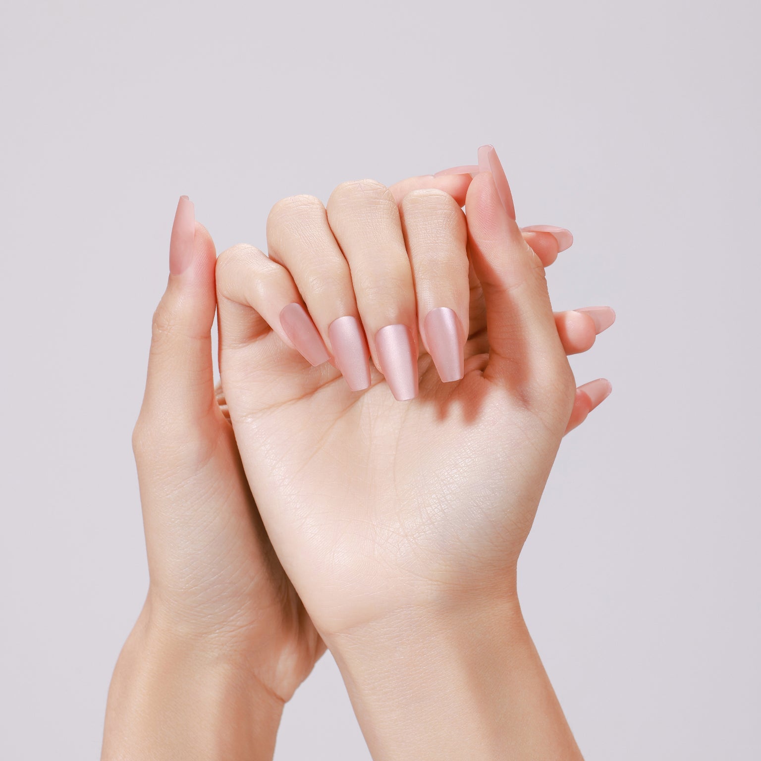 Hands wearing Peach Kiss long coffin peach nude glossy press-on nails