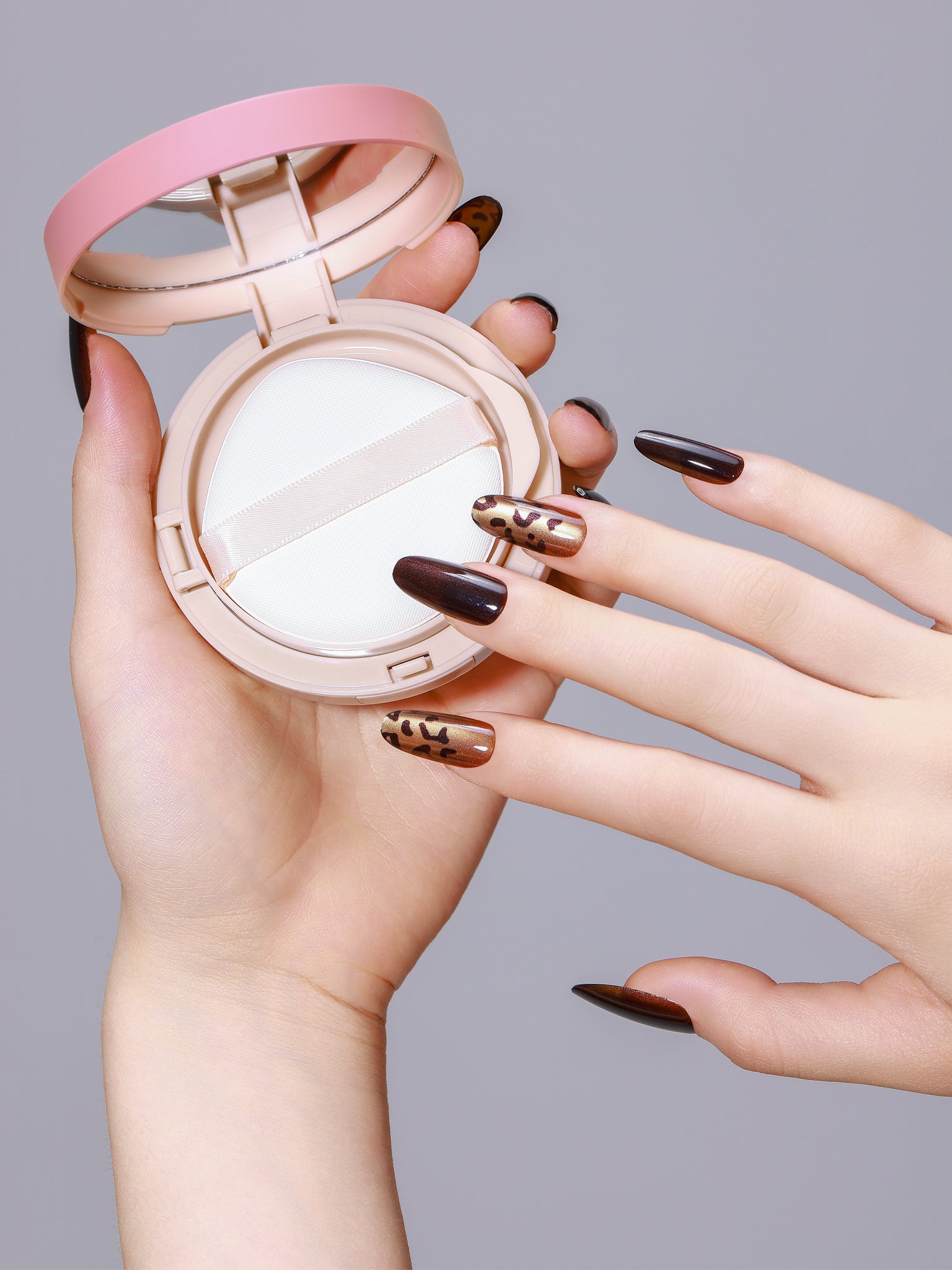 Hand wearing Safari Queen long oval bronze leopard press-on nails with glossy gel finish