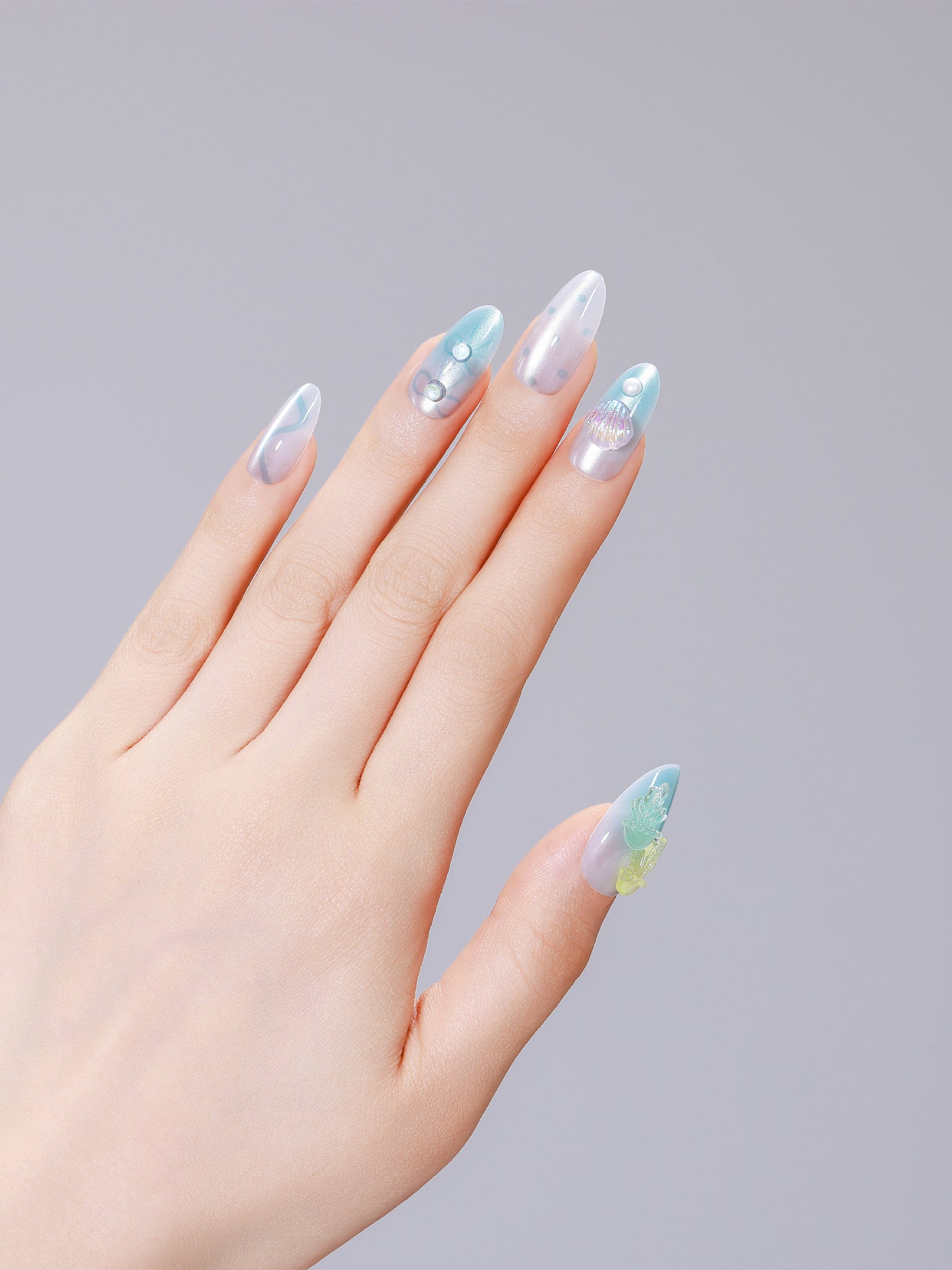 Hands wearing Jellyfish Dreams long almond clear jelly nails with aqua swirls and pearl accents