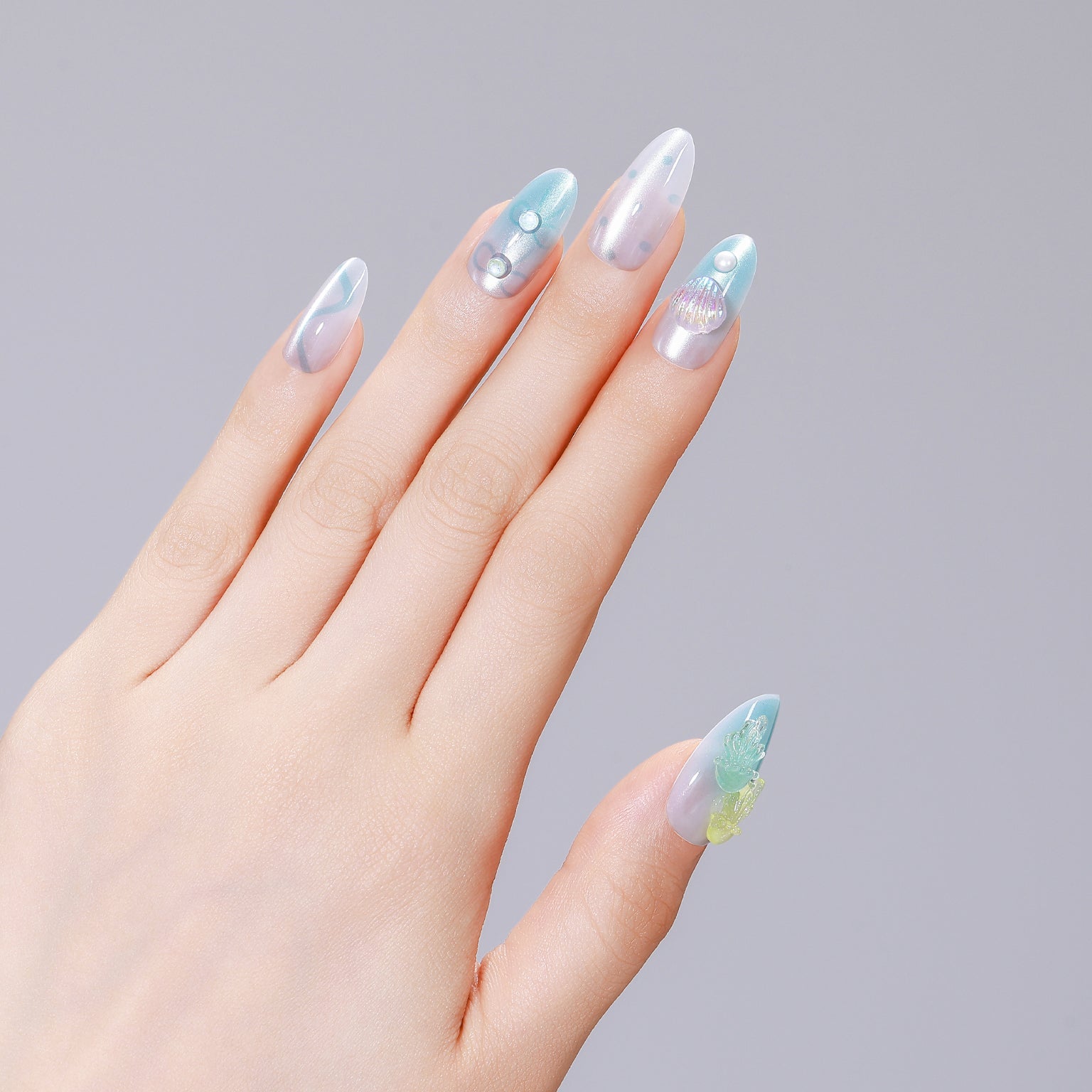 Hands wearing Jellyfish Dreams long almond clear jelly nails with aqua swirls and pearl accents