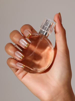 Hand wearing Gold Rush gold French tip square press on nails for minimal glam look