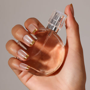 Hand wearing Gold Rush gold French tip square press on nails for minimal glam look