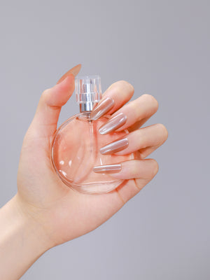 Hand wearing Moonlit Beige long oval beige nude press-on nails with glossy gel finish