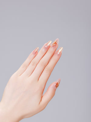 Close up of nude almond press on nails with gold firework bursts and white stars