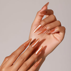 Hand wearing Citrus Crush long stiletto copper orange chrome press on nails reflective metallic manicure
