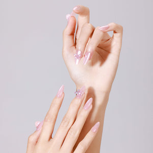 Hand wearing Silk Butterfly long almond glazed pink press-on nails with 3D butterfly accent nail