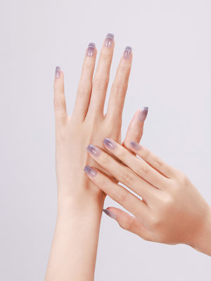 Model wearing a full set of dreamy Lavender Dusk ombre press-on nails in a medium square shape