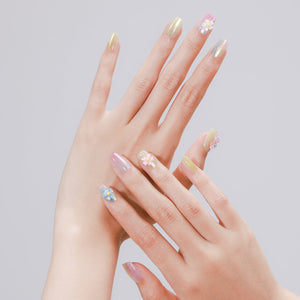 Hand wearing Candy Pop pastel dragonfly and daisy square press on nails for cute spring manicure