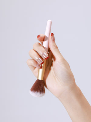 Close up of Fortune Spark nude press on nails with red French tips and gold foil accents