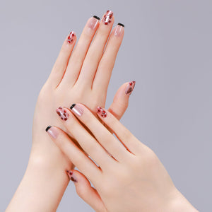Hands wearing Shadowed Rose leopard French square press-on nails with nude base and black tips