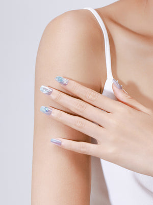 Hand wearing Ocean Mirage ocean blue glitter square press on nails with mermaid-inspired shimmer