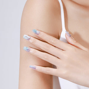 Hand wearing Ocean Mirage ocean blue glitter square press on nails with mermaid-inspired shimmer