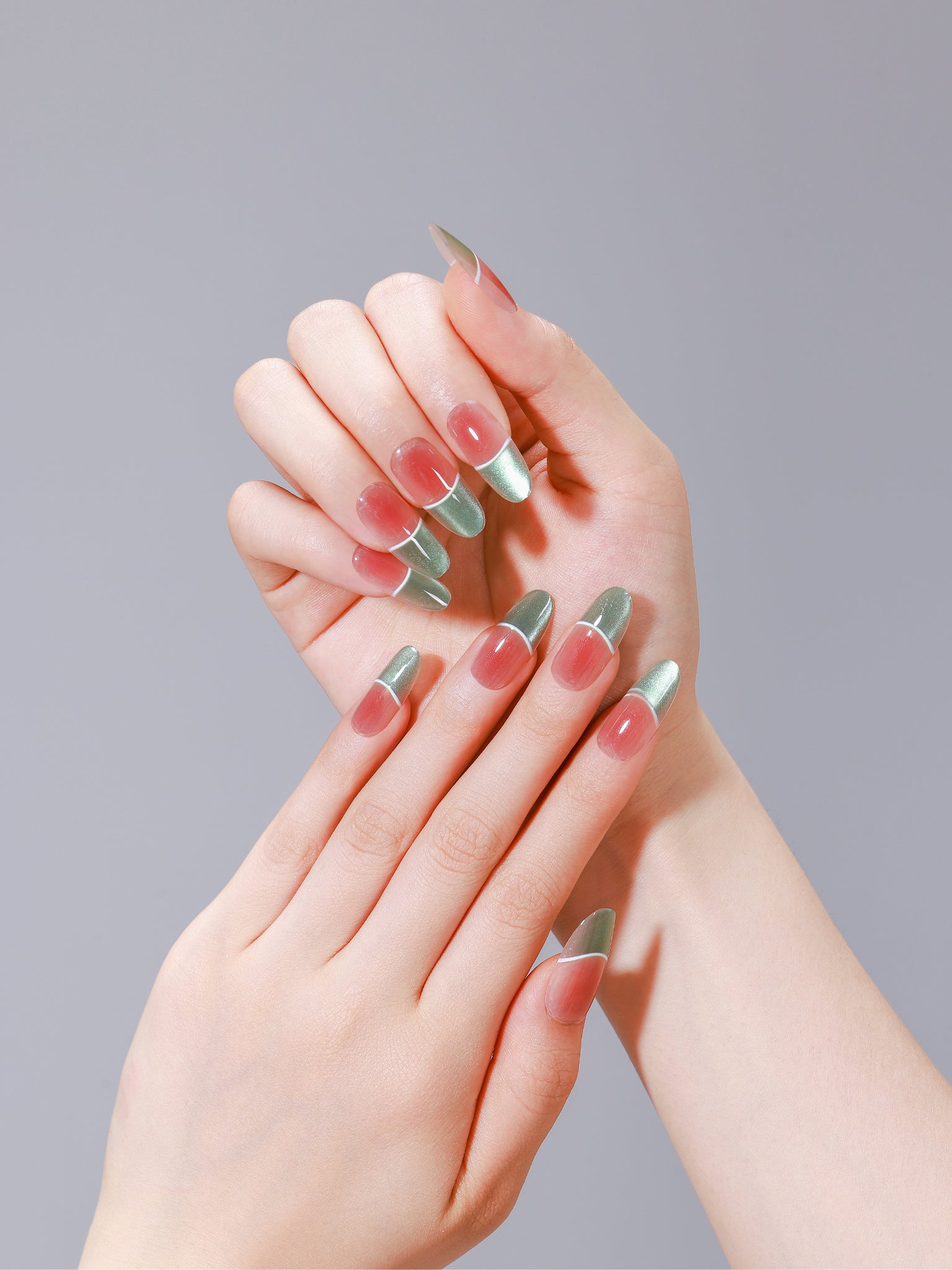 Hands wearing Fresh Meadow long oval green chrome French tip nails with peach base