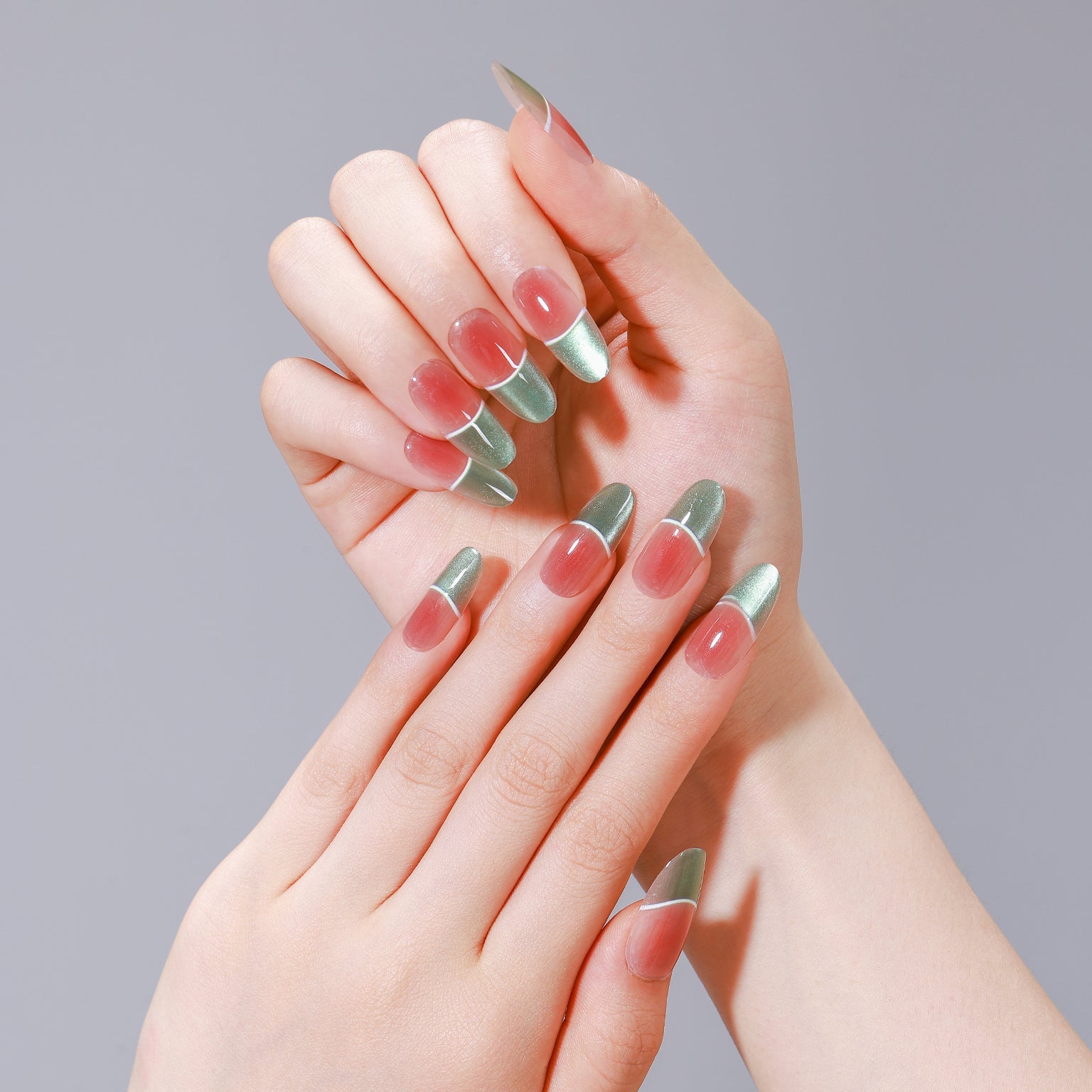 Hands wearing Fresh Meadow long oval green chrome French tip nails with peach base