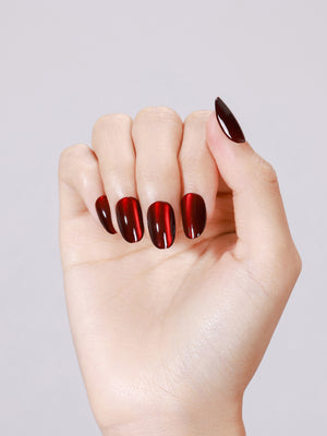 Hand wearing Blood Moon red cat eye short oval press on nails for bold night out look