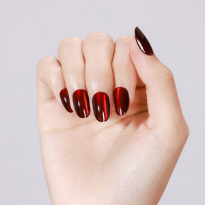 Hand wearing Blood Moon red cat eye short oval press on nails for bold night out look