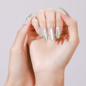 Hand wearing Spring Garden long almond mint green chrome press-on nails with white floral accent