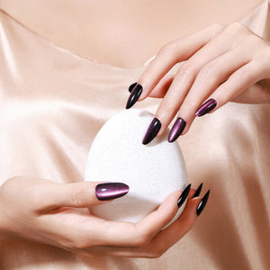 Hand wearing Velvet Flash long almond blackberry plum cat eye press-on nails glossy black accent manicure