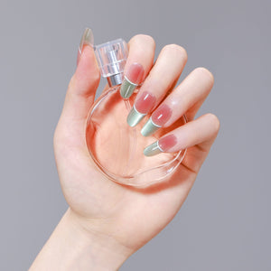 Hand holding perfume bottle wearing Fresh Meadow green chrome French tip press-on nails