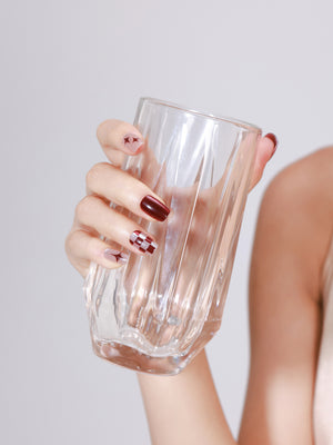 Hand wearing Ruby Sparkle red glitter checker star square press on nails for holiday party look