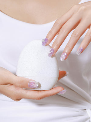 Hand wearing Ocean Princess mermaid-inspired press-on nails with pastel lilac ombré and 3D pearl accents