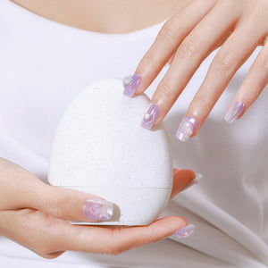 Hand wearing Ocean Princess mermaid-inspired press-on nails with pastel lilac ombré and 3D pearl accents