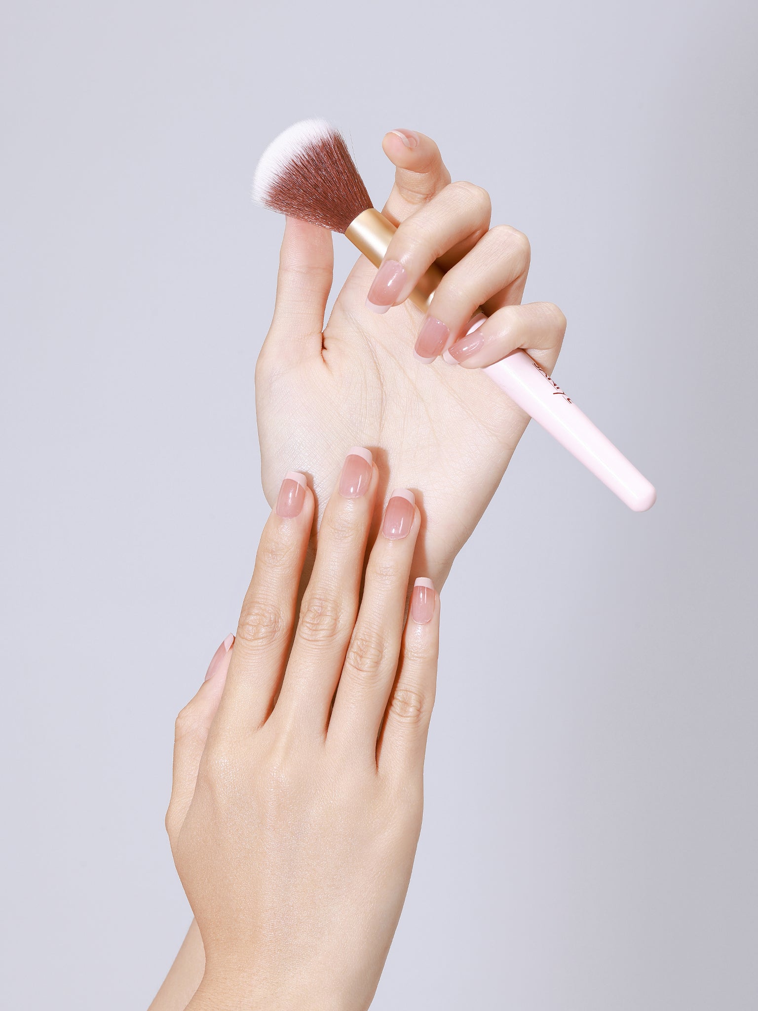 Hand wearing Nude Illusion nude French press-on nails with glossy gel finish