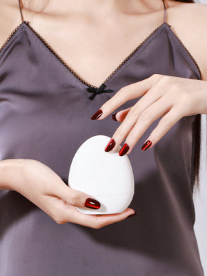 Hand wearing Blood Moon red cat eye short oval press on nails for bold night out look