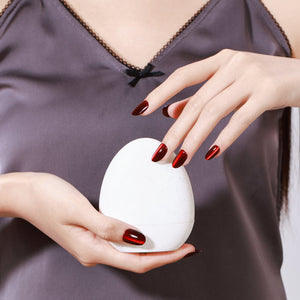 Hand wearing Blood Moon red cat eye short oval press on nails for bold night out look