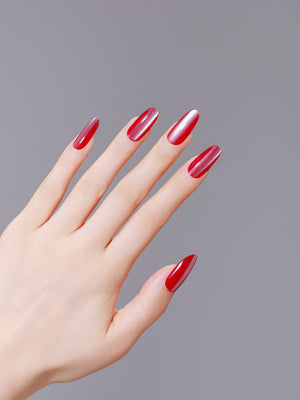 Hand wearing Rose Quartz red cat eye long oval press on nails for bold night out manicure