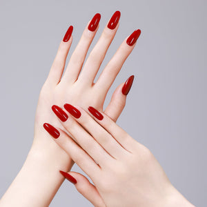 Hand wearing Fire & Desire fiery red long oval press on nails for bold, feminine manicure