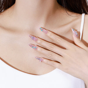 Both hands showing Star of the Tide glossy nude ocean press-on nails with iridescent sparkle