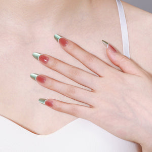 Close-up of Fresh Meadow long oval mint green French tip press-on nails on peach base