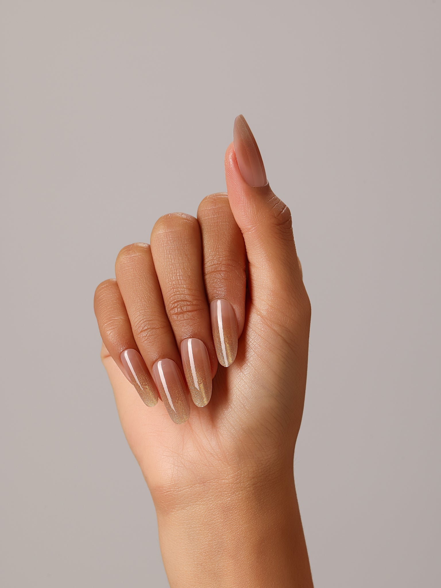Full set showing Sunlit Nude long oval nude press-on nails with luminous gold fade