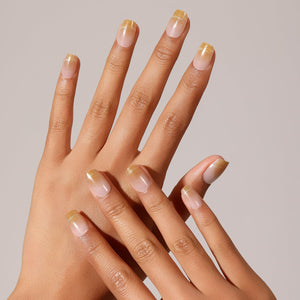 Hand wearing Champagne Drip glossy champagne gold fade press-on nails square ombre manicure