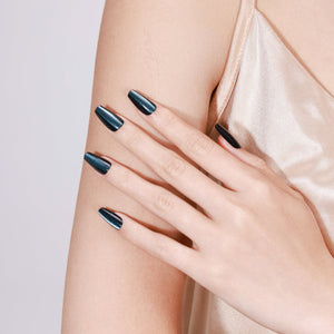 Close-up of arm showing Midnight Kiss long coffin midnight blue glossy metallic press-on nails