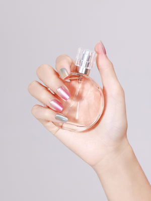 Hand holding perfume bottle wearing Crystal Candy short square chrome press-on nails