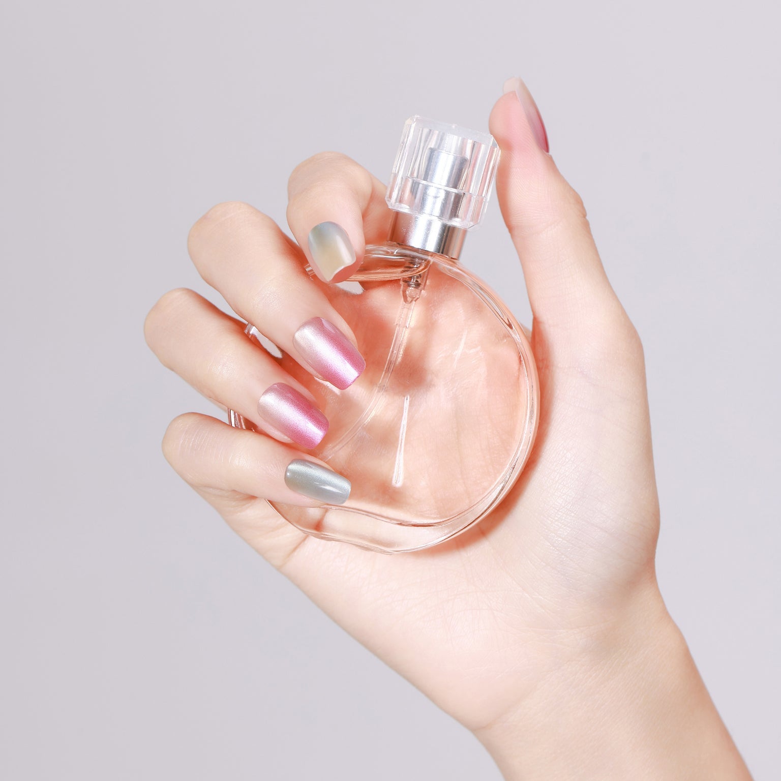 Hand holding perfume bottle wearing Crystal Candy short square chrome press-on nails