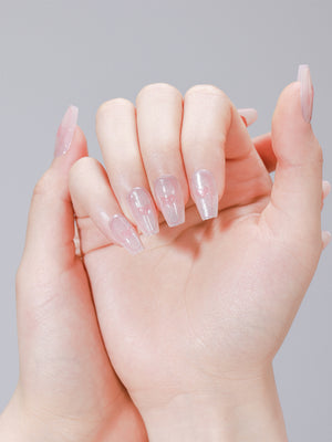 Hand wearing Cupid Glow pink heart glitter coffin press on nails with glossy finish