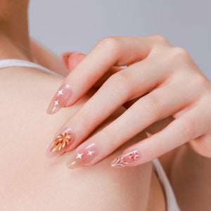 Hand wearing Firework Bless nude gold firework almond press on nails with gold shimmer bursts