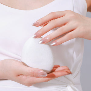 Hand wearing Latte Dust long oval latte nude press-on nails with glossy gel finish