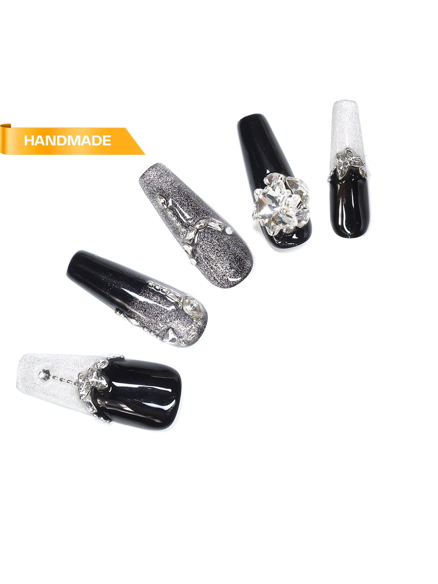 Handmade long coffin press-on nails in black and silver glitter with rhinestone cross accents on white background
