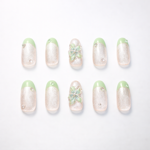 Mint green French tip medium almond press-on nails with pearly champagne cat-eye shimmer, fine glitter, rhinestone accents, and 3D iridescent flower accent nails