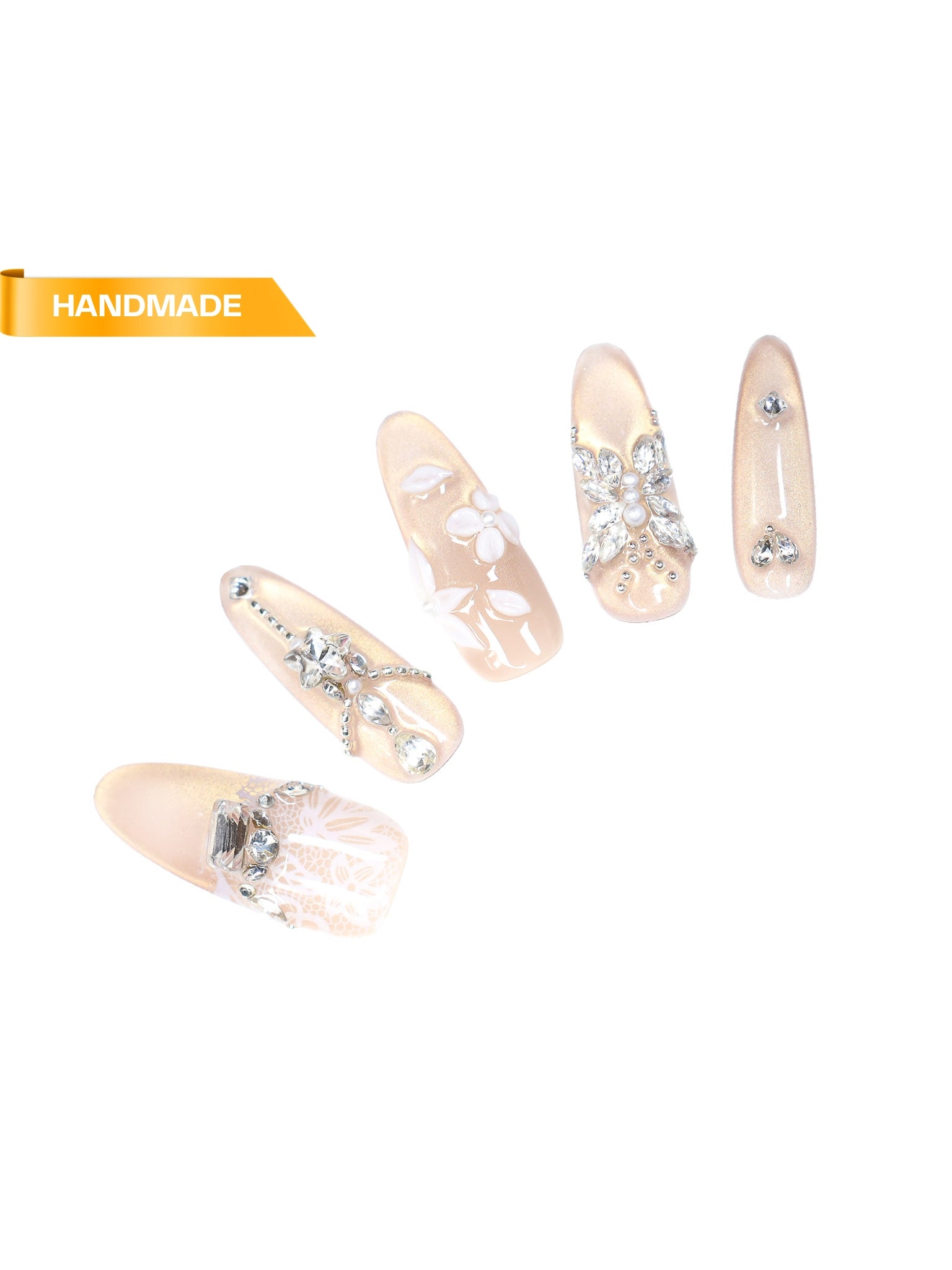 Handmade long almond press-on nails in champagne nude with glitter finish, rhinestone floral accents, and lace detailing on white background