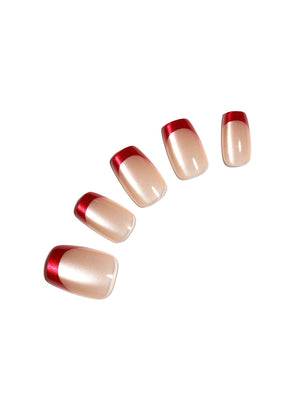 Red French tip press-on nails with nude base and metallic red tips
