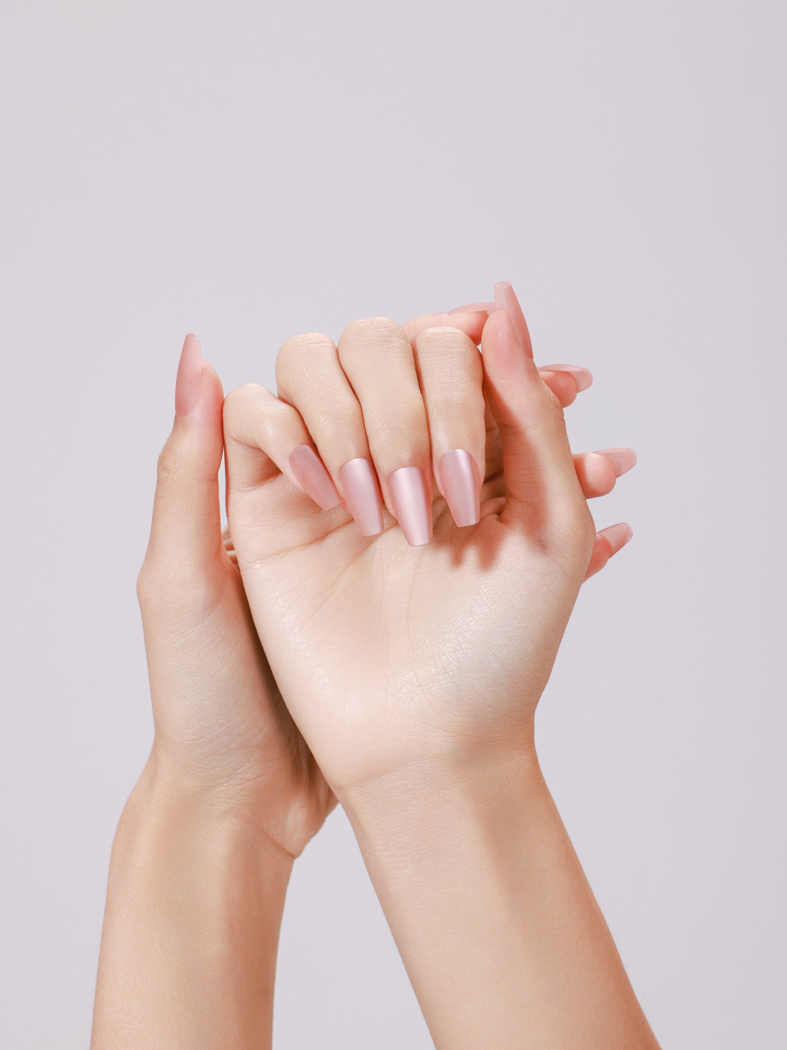 Hands wearing Peach Kiss long coffin peach nude glossy press-on nails