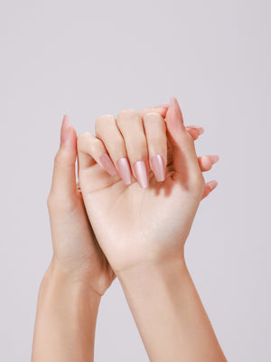 Hands wearing Peach Kiss long coffin peach nude glossy press-on nails