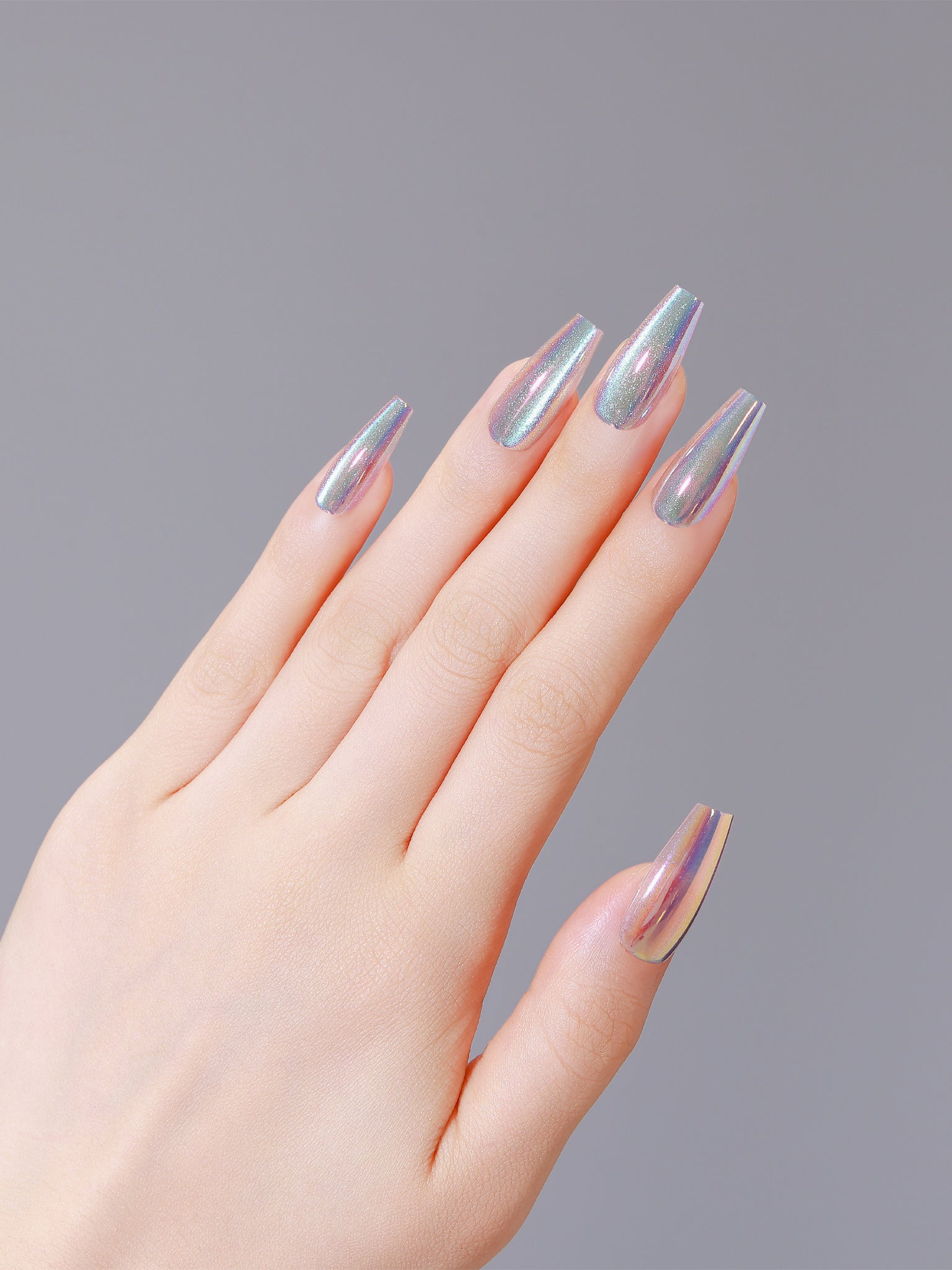 Hand showing holographic metallic coffin press-on nails that reflect rainbow colors