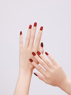 Hand wearing Drama Queen matte red square press on nails for bold night-out look